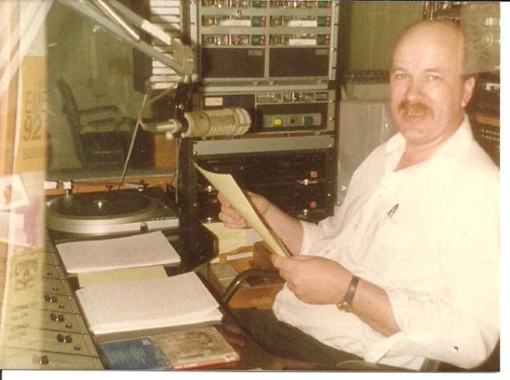 Man holding a paper beside a studio turntable