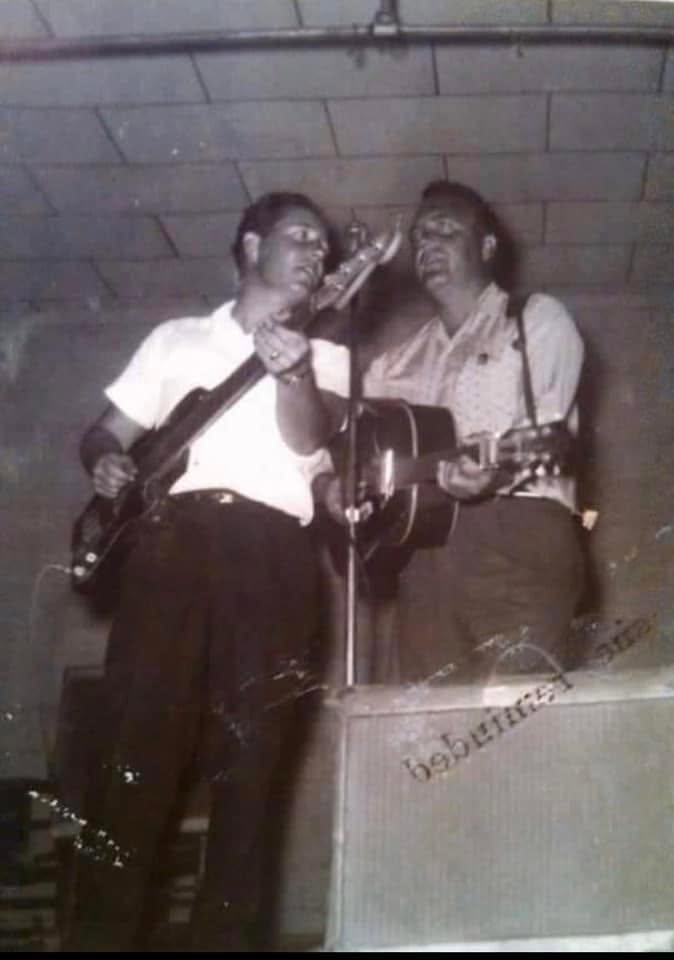 Two country musicians performing together with guitars